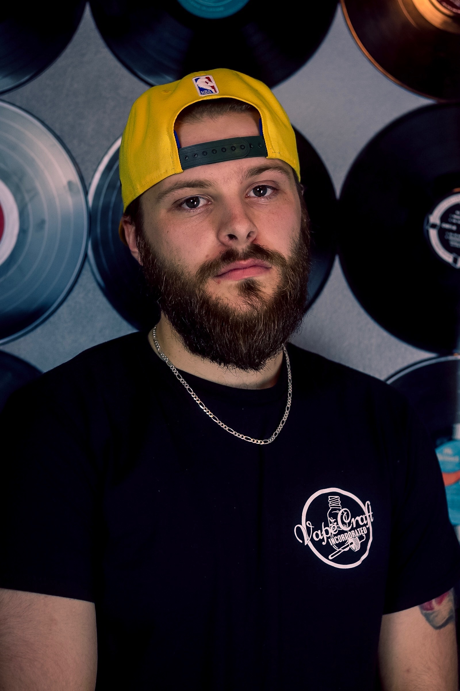 Slingshott standing in front of a wall of vinyl records